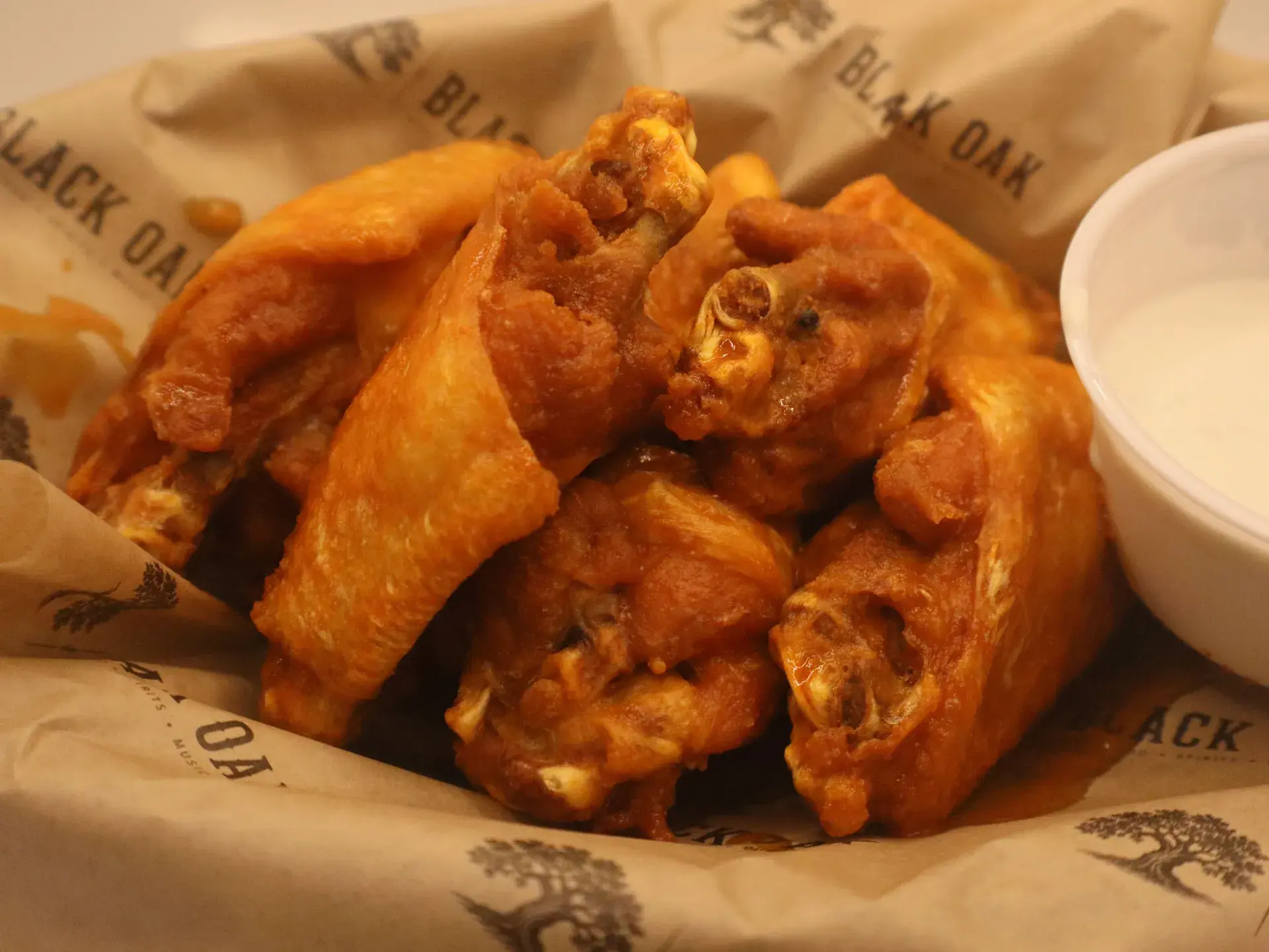 Buffalo wings in cayenne sauce in a Black Oak basket.