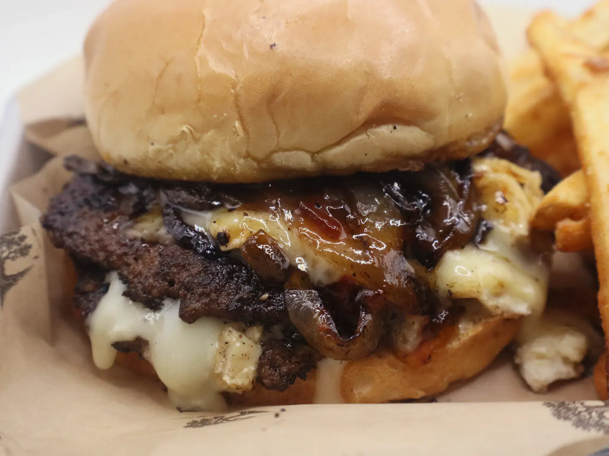 The Vault burger at The Black Oak — melted white cheese and caramelized onions over a charred patty.